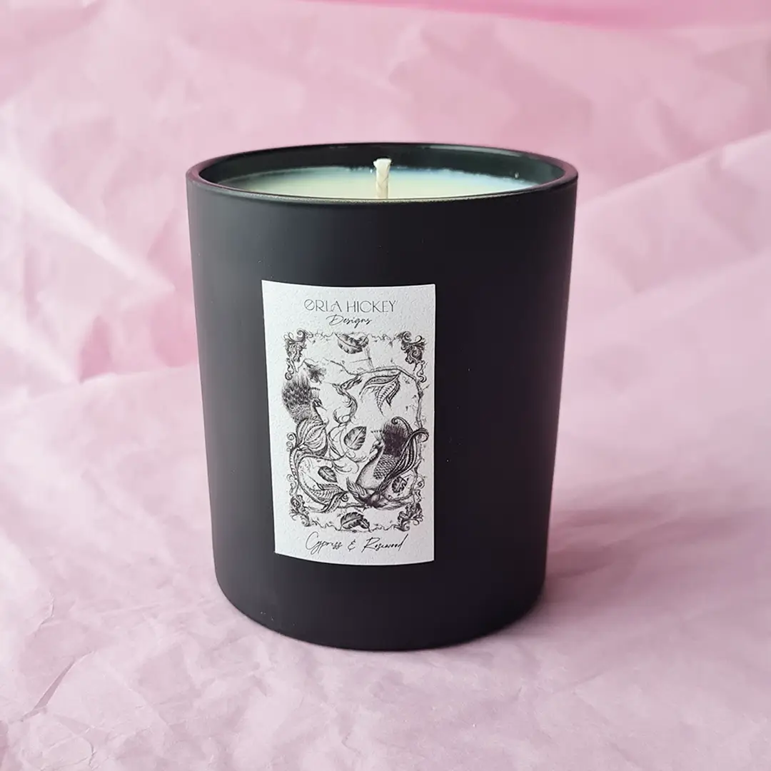 Orla Hickey Designs matt black candle sitting on a pink background